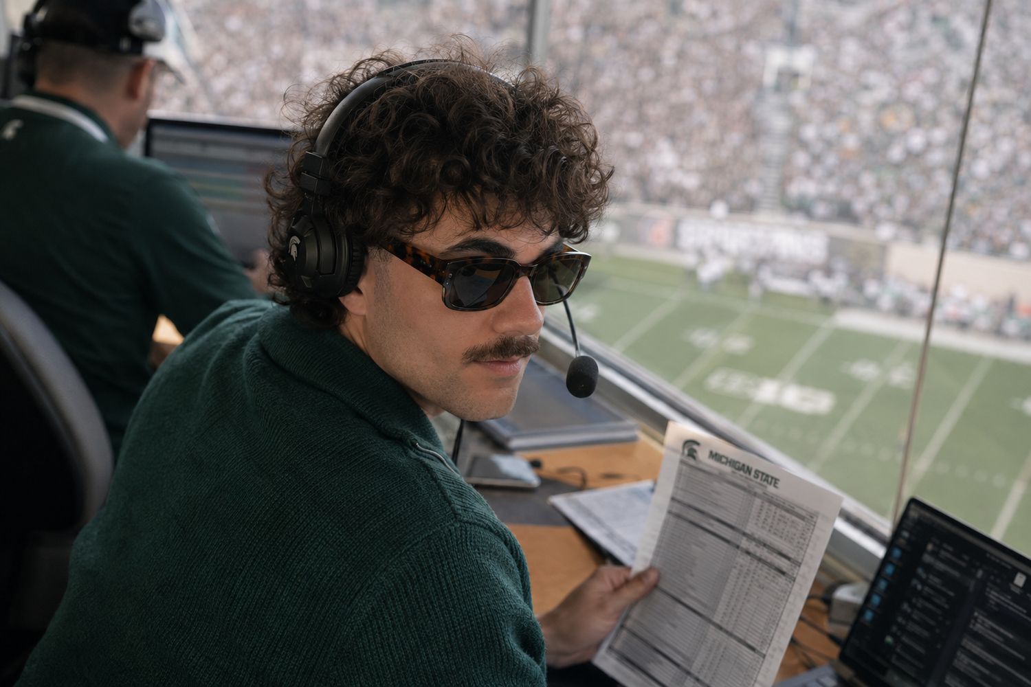 Nick Mansour seated in the coaches’ booth during a walkthrough
